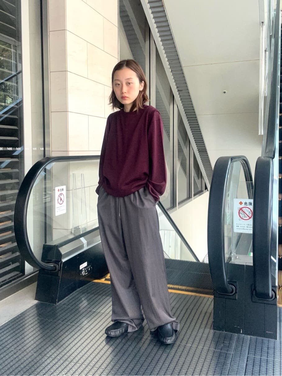 レイヤードニットとサテンパンツを着た女性