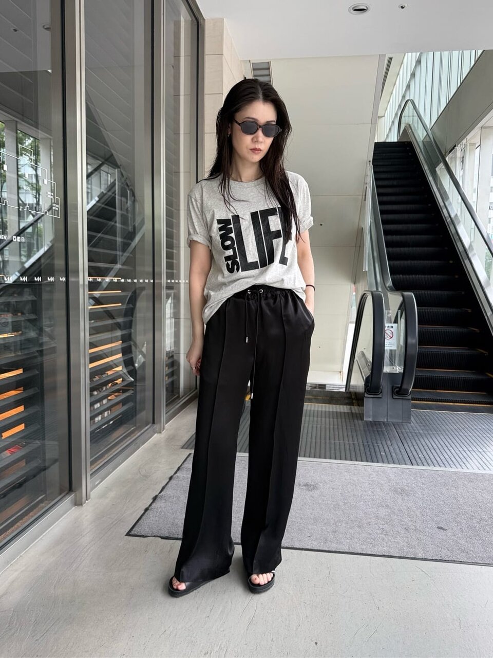 ロゴTシャツとサテンパンツを着た女性