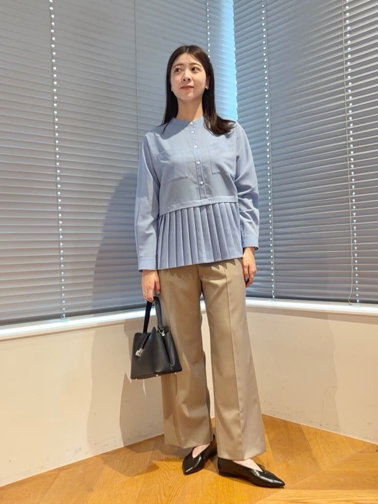 サックスブルーのシャツとワイドパンツを着た女性