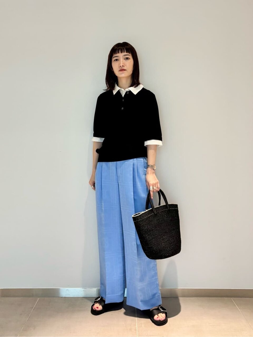 襟付きニットとサックスブルーのパンツを着た女性