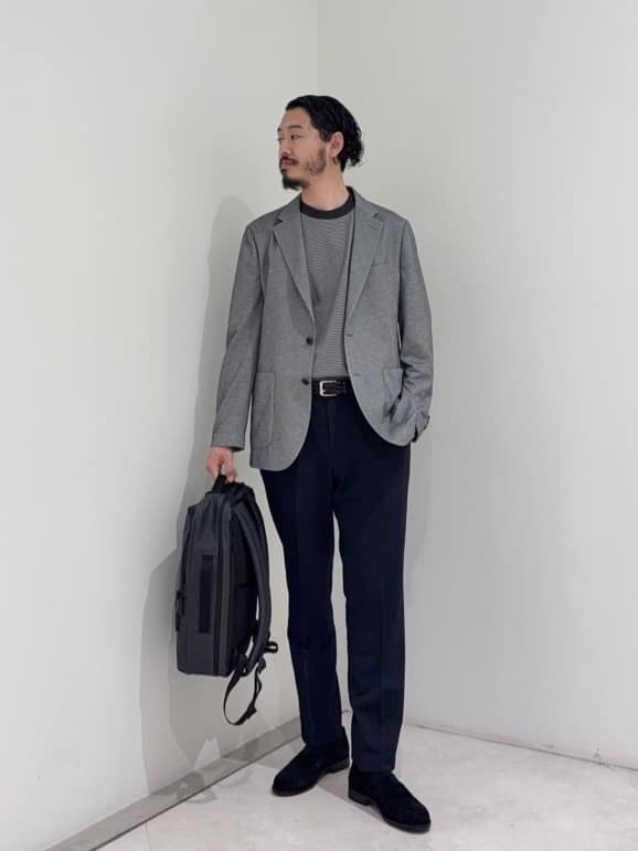 グレーのジャケットとボーダーのTシャツを着た男性