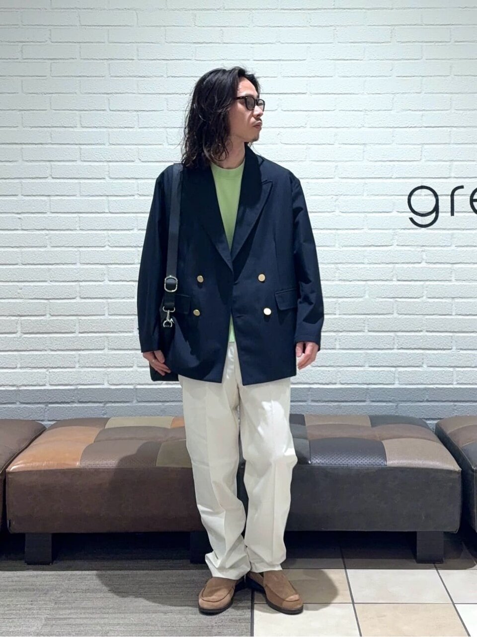 ネイビーのジャケットとライムのTシャツを着た男性