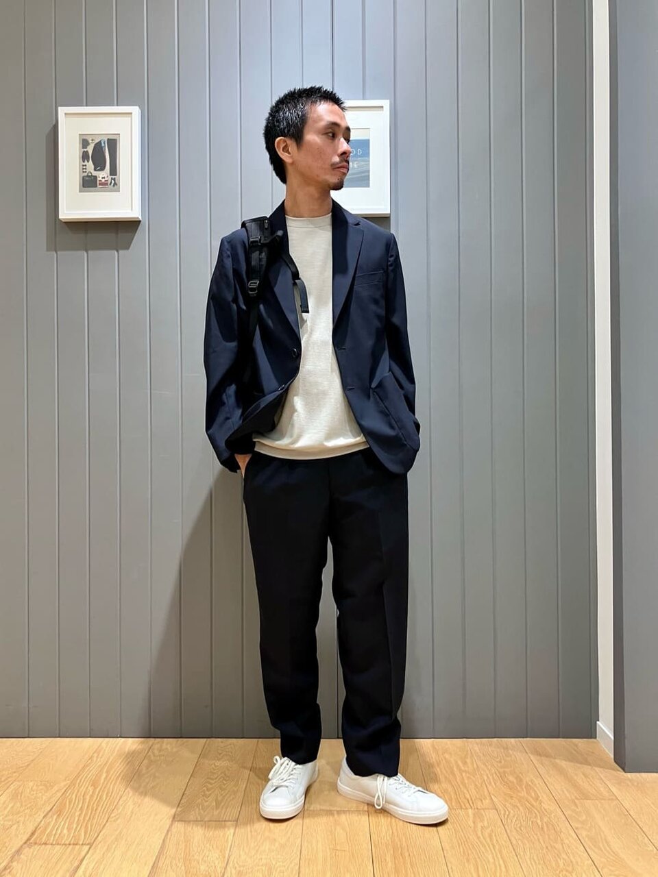 ネイビーのジャケットとベージュのTシャツを着た男性