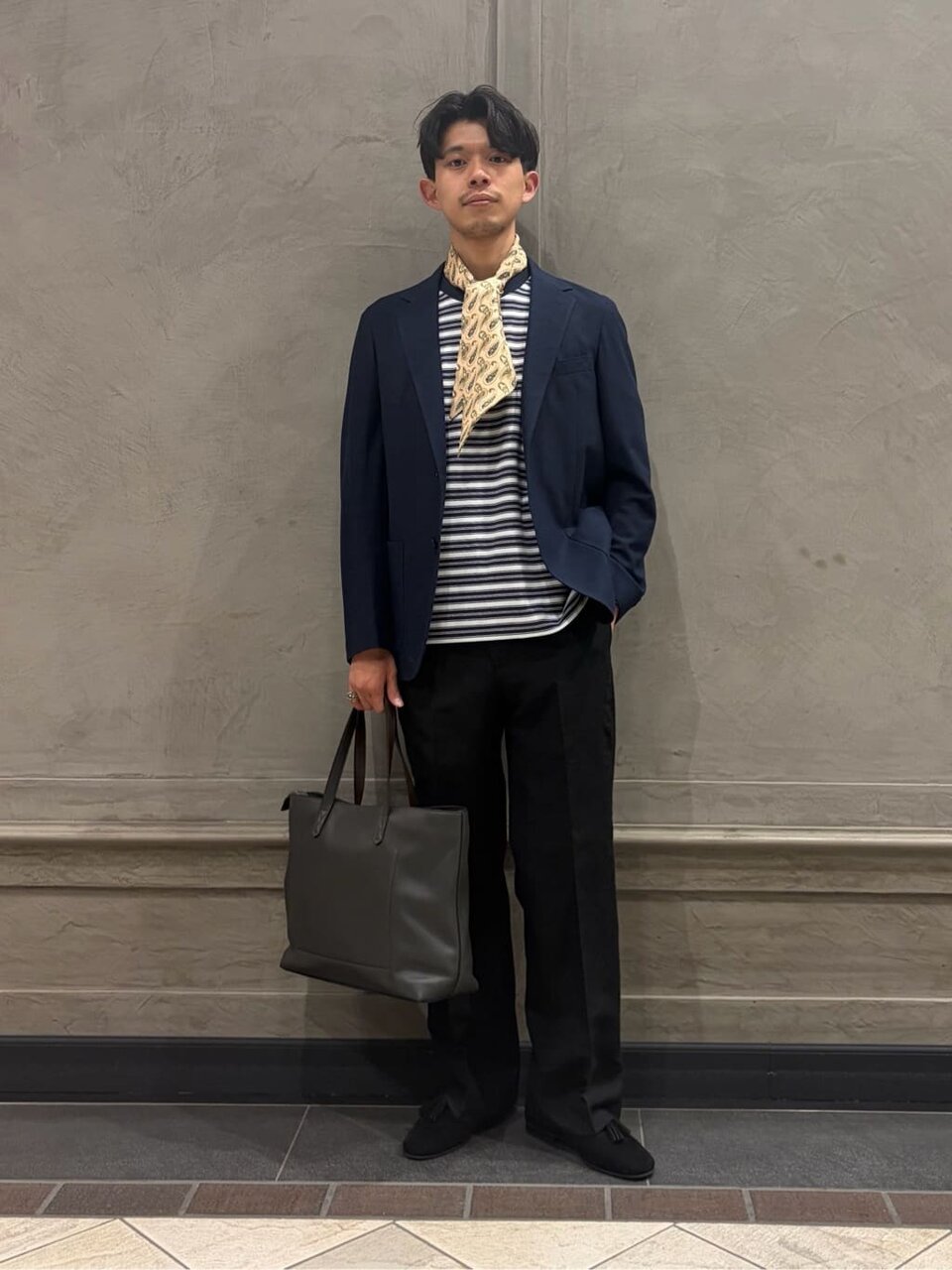 ネイビーのジャケットとボーダー柄のTシャツを着た男性
