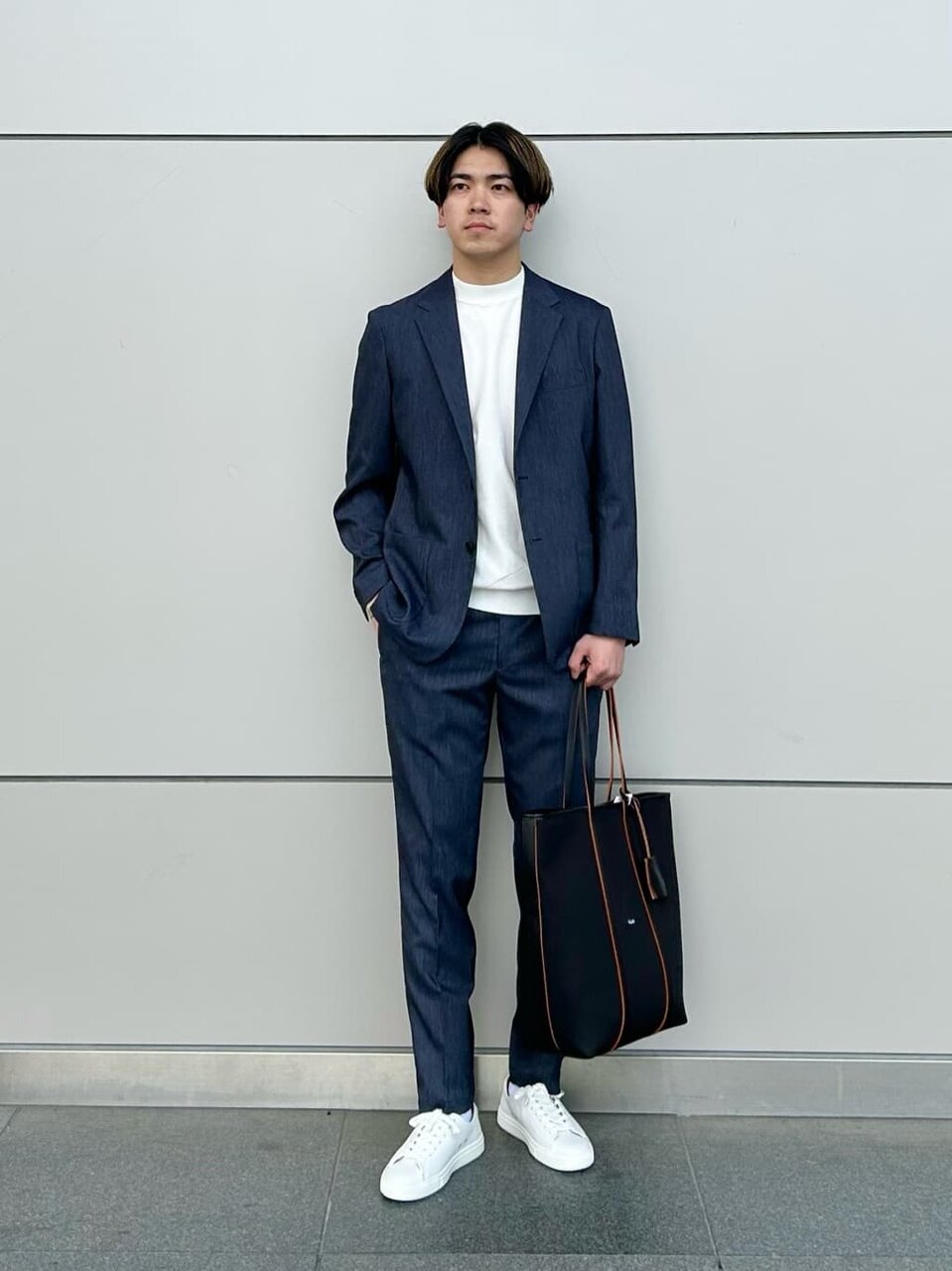 ネイビーのジャケットと白のTシャツを着た男性
