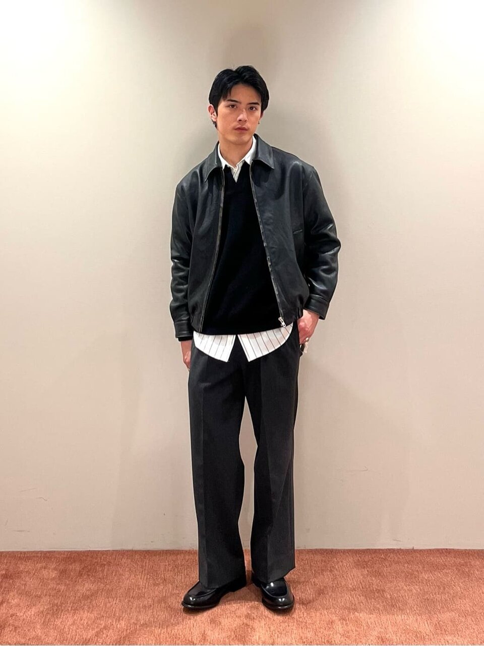レザージャケットとスラックスを着た男性