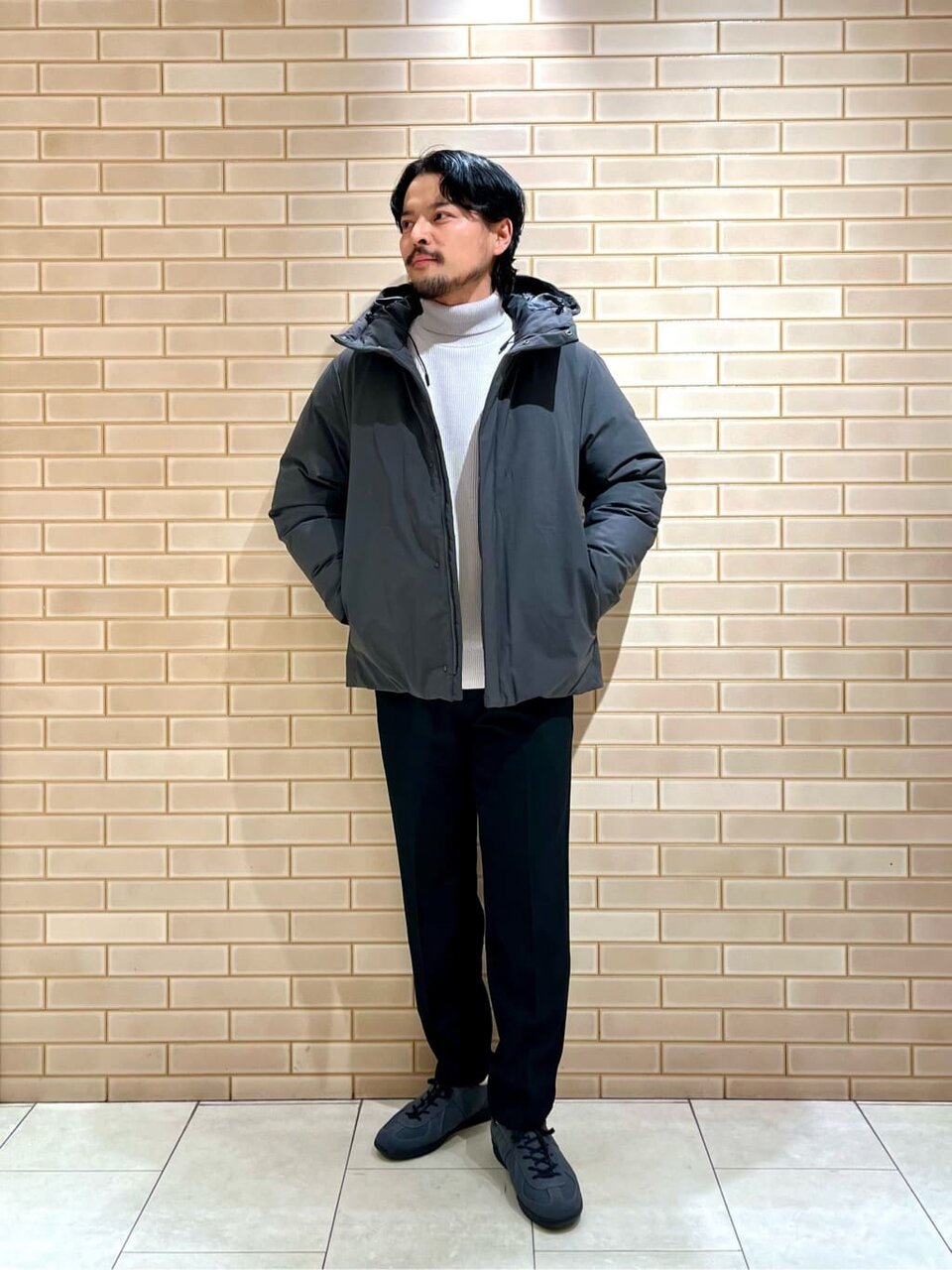 ダウンジャケットとタートルネックニットを着た男性