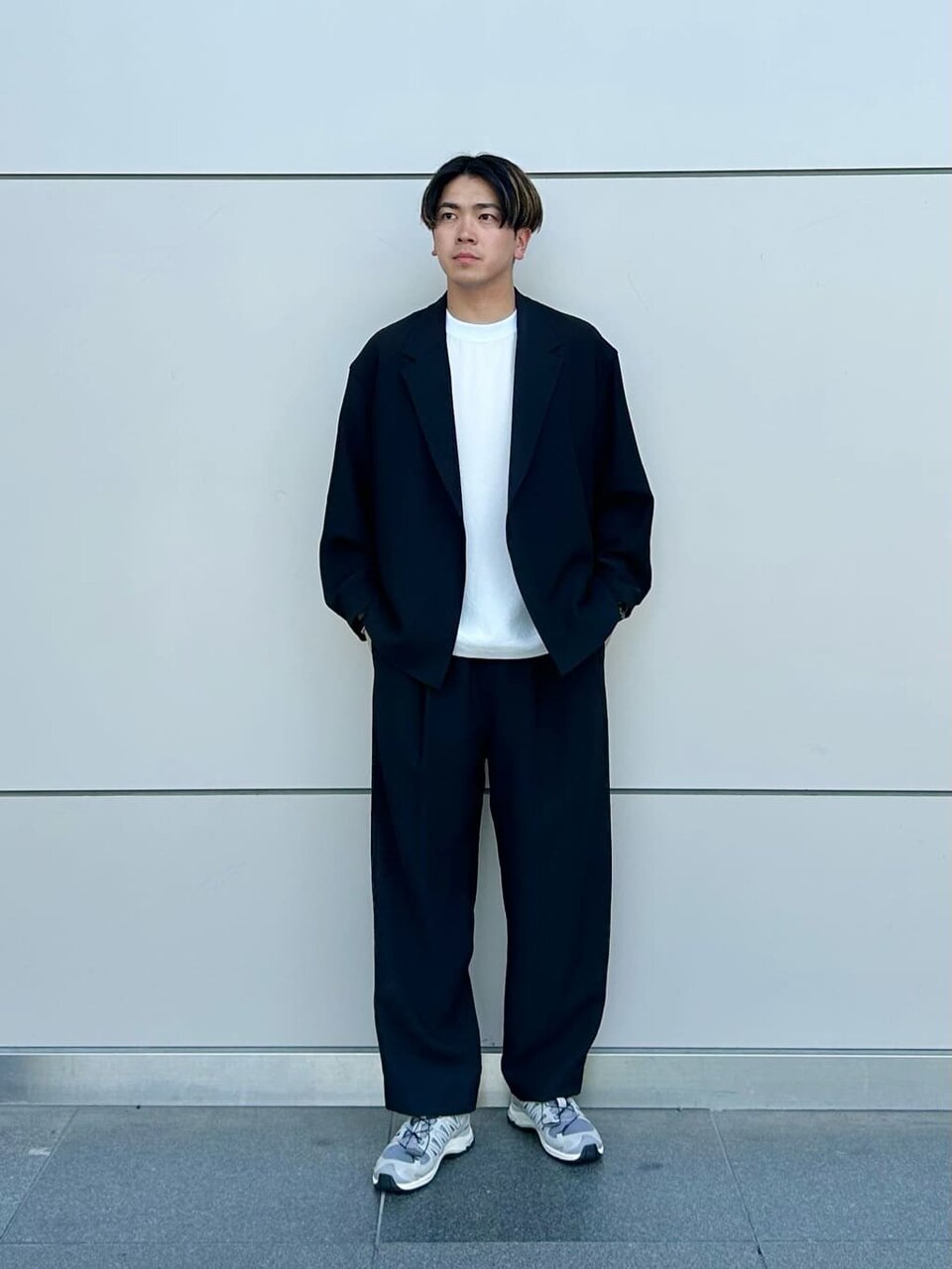 黒のジャケットセットアップを着た男性