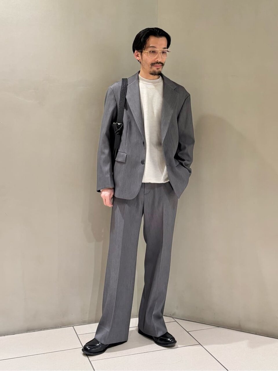 グレーのジャケットセットアップを着た男性