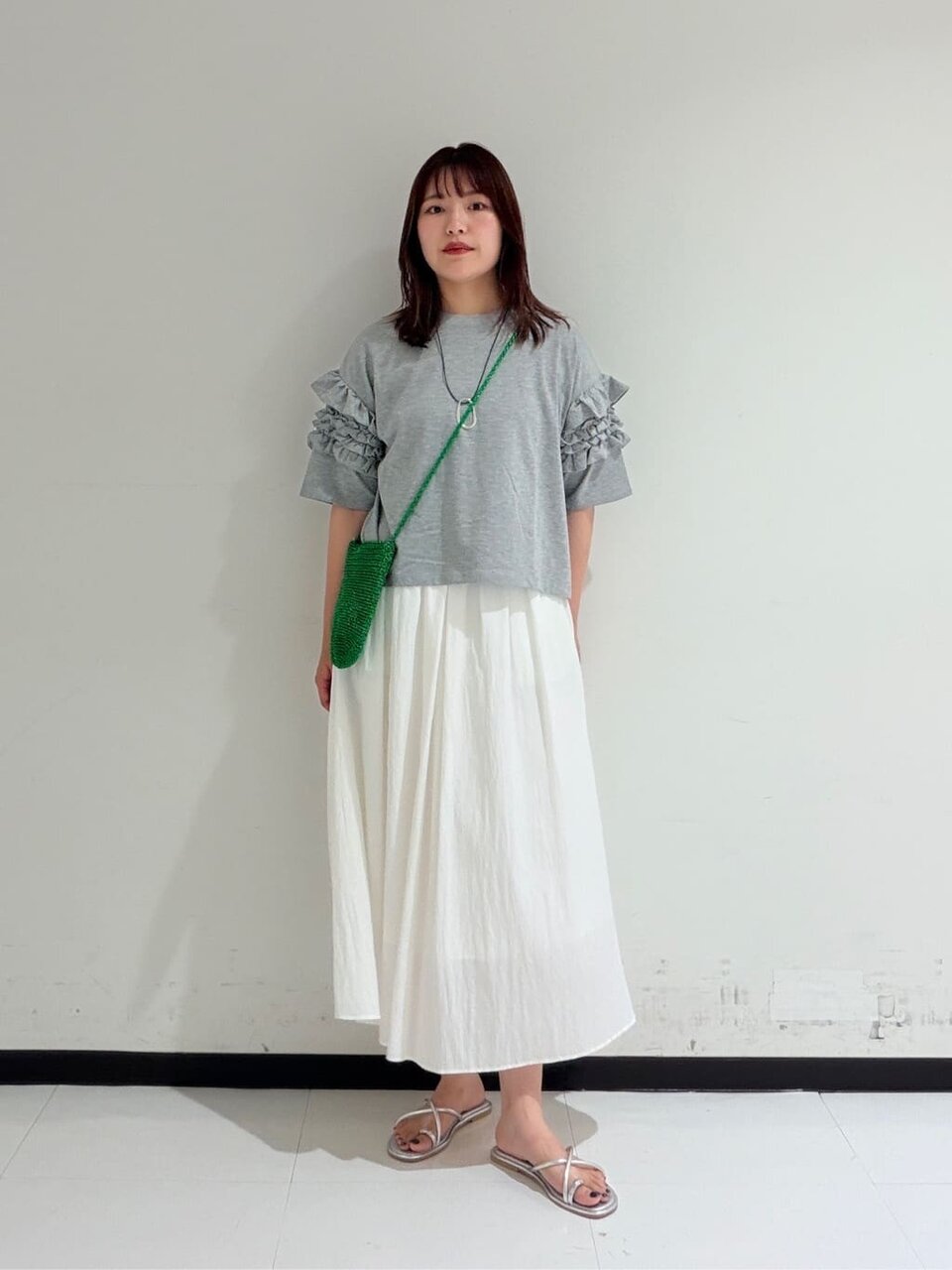 フリルスリーブカットソーとフレアスカートを着た女性
