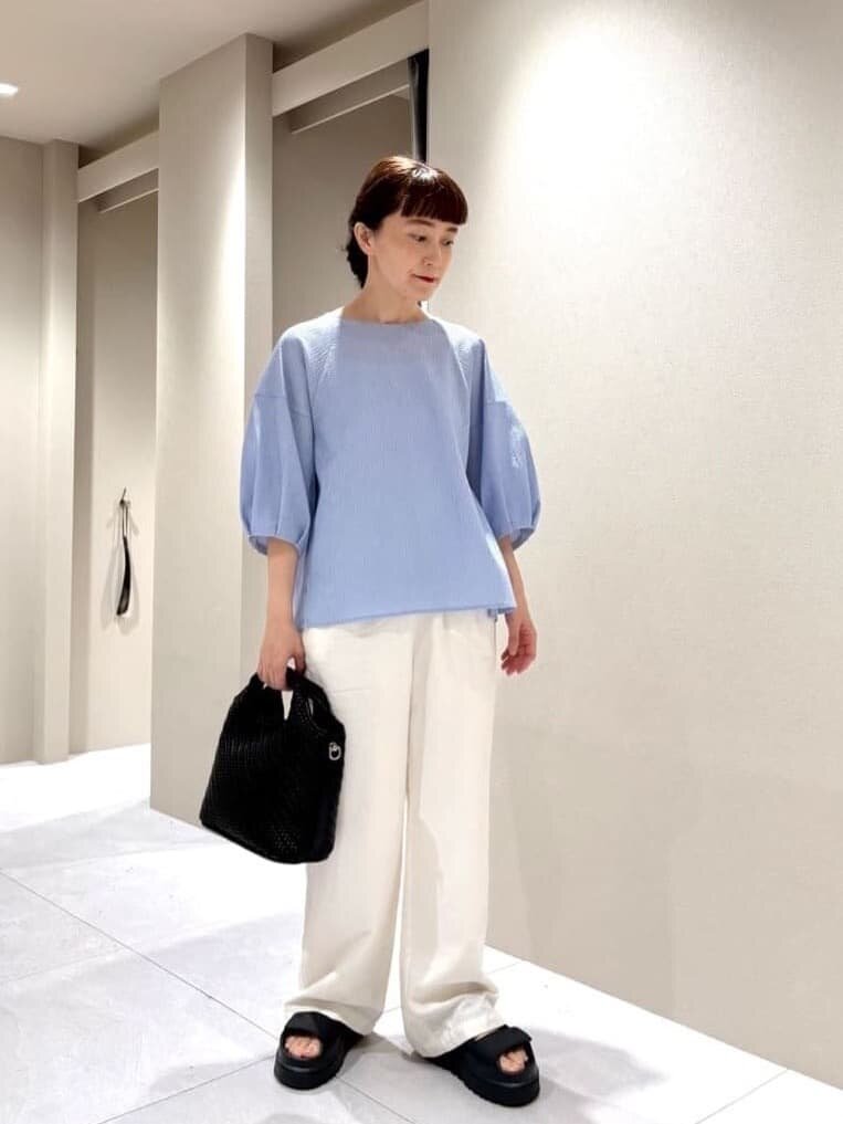 タックスリーブカットソーとワイドパンツを着た女性