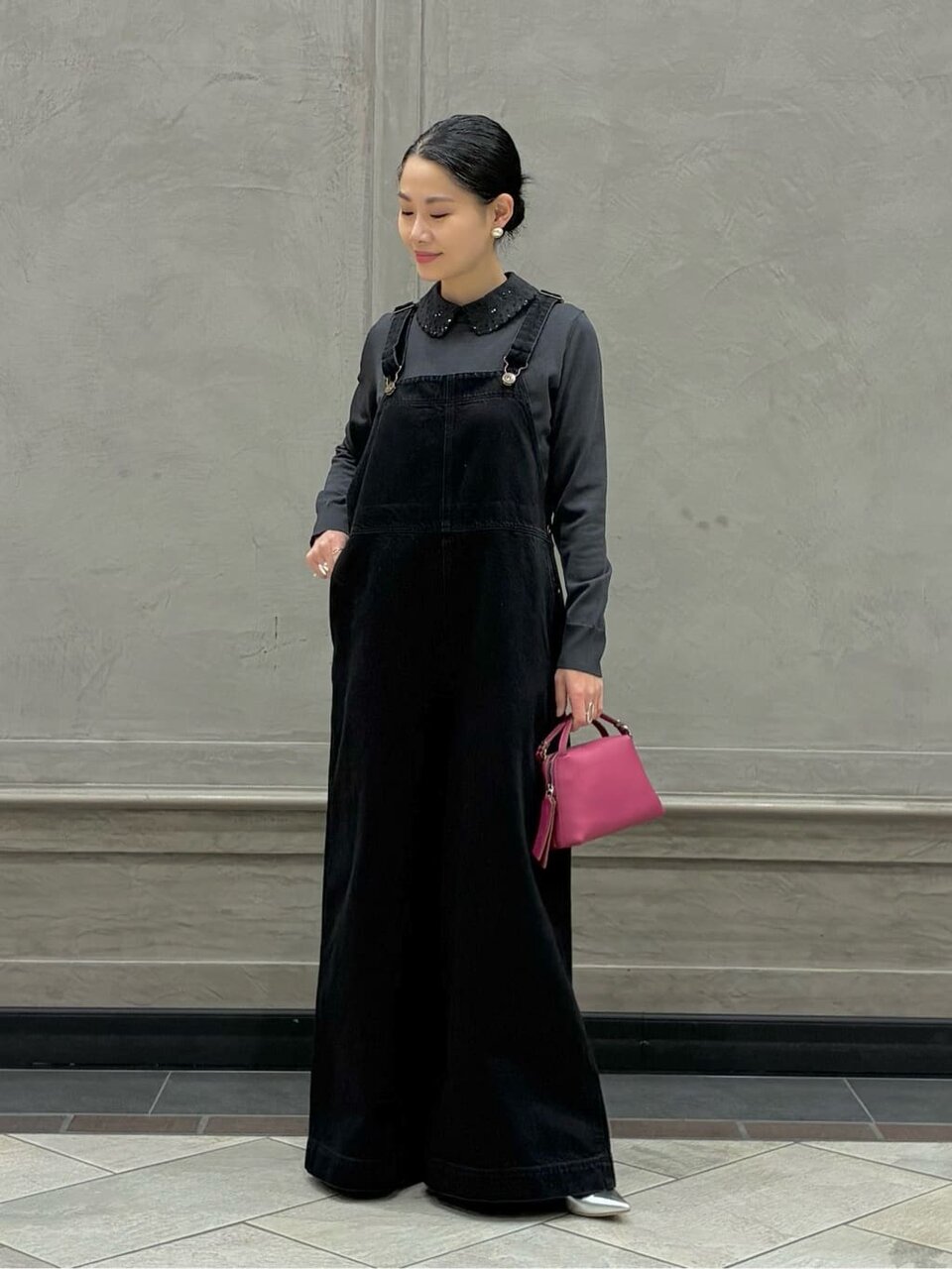 ニットとデニムサロペットを着た女性