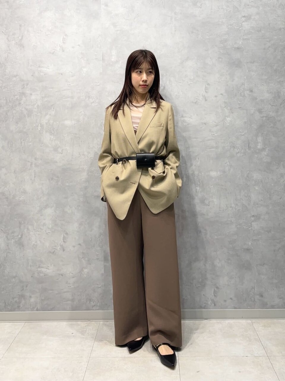 テーラードジャケットとレースサロペットを着た女性
