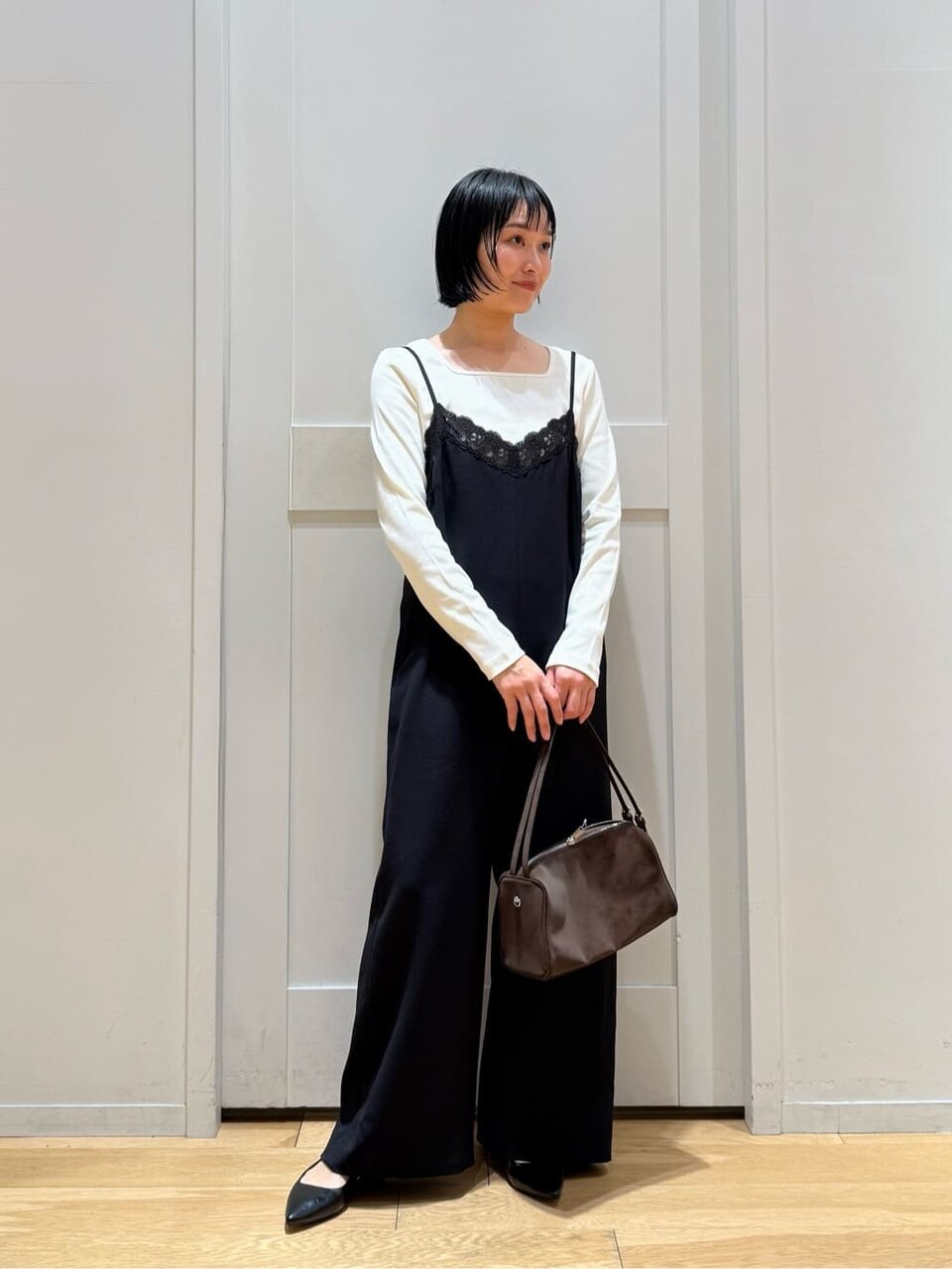 カットソーとレースサロペットを着た女性