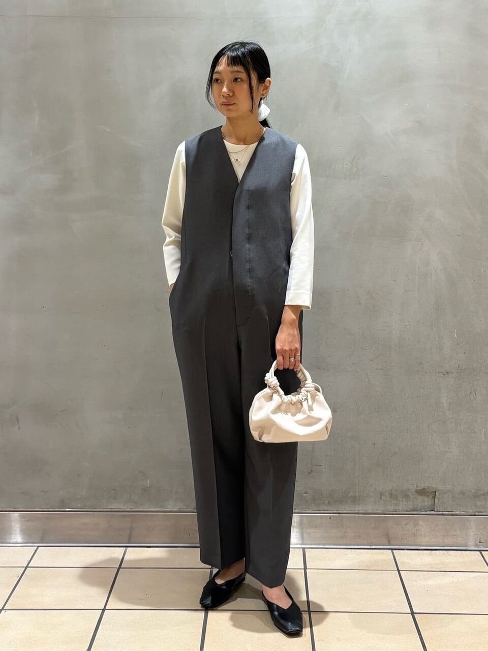 クルーネックブラウスとサロペットを着た女性