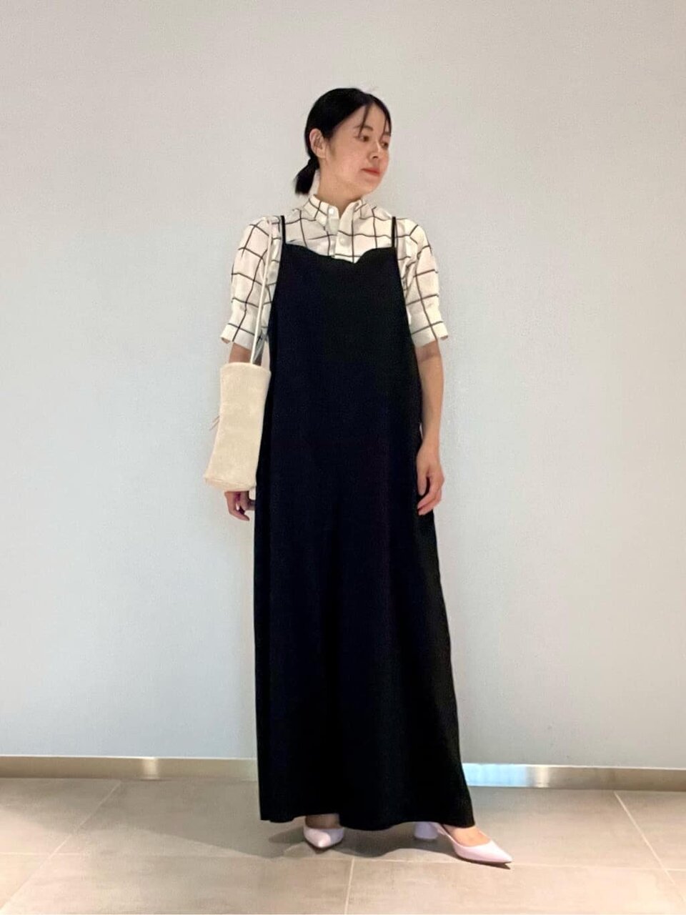 シアーチェック柄シャツとサロペットを着た女性