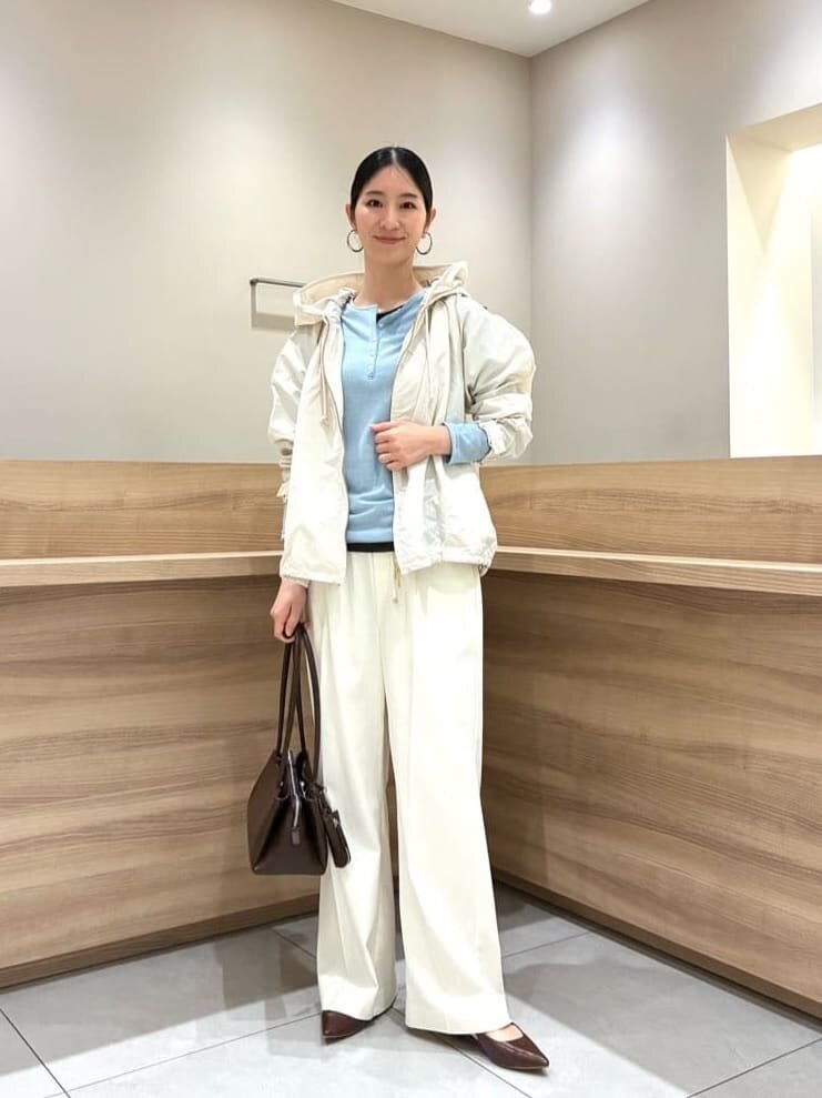 白のパンツに水色のトップスをあわせた女性