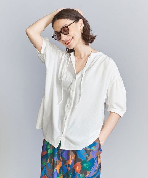 スキッパーデザインのシャツを着た女性