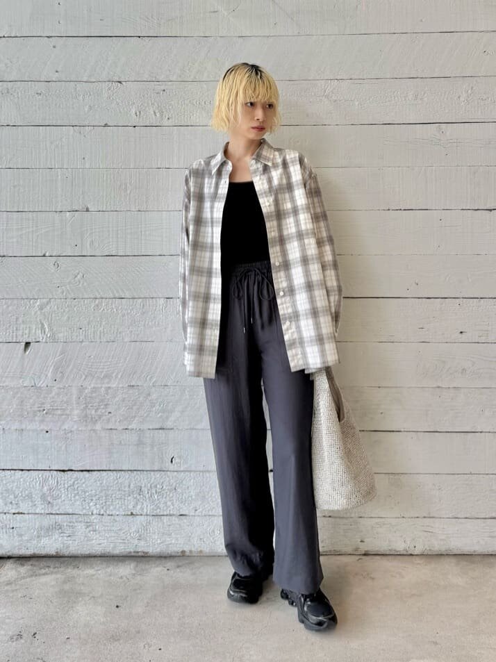 チェック柄シャツをパンツにあわせた女性