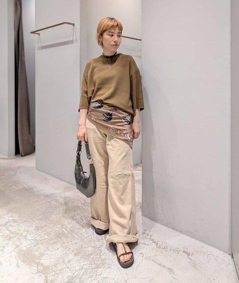  オリーブカラーのニットを着た女性