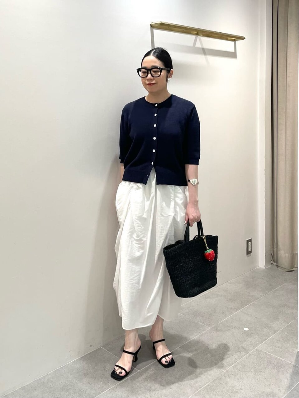 カーディガンとシャーリングスカートを着た女性