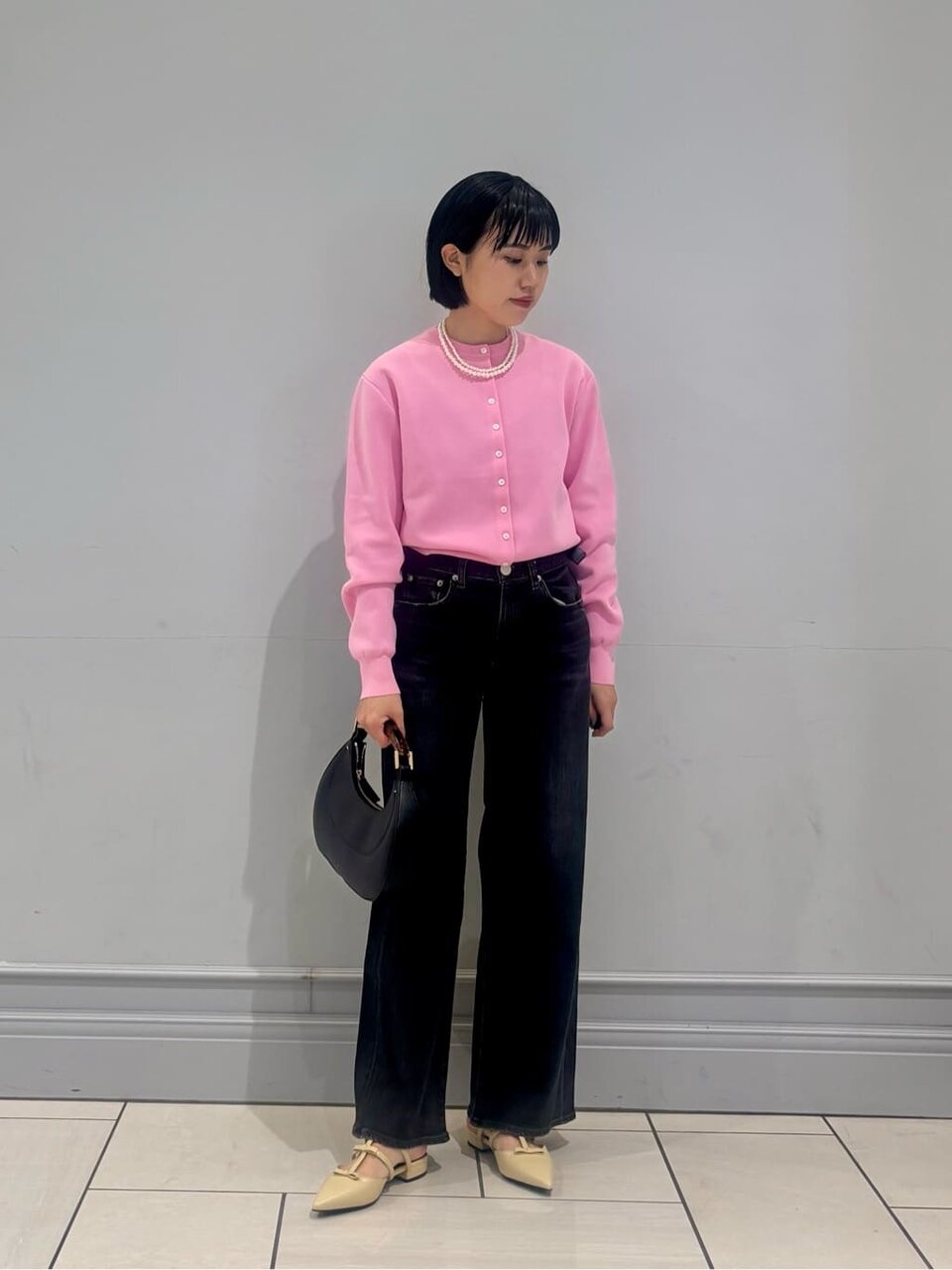 カーディガンとパールネックレスを身につけた女性