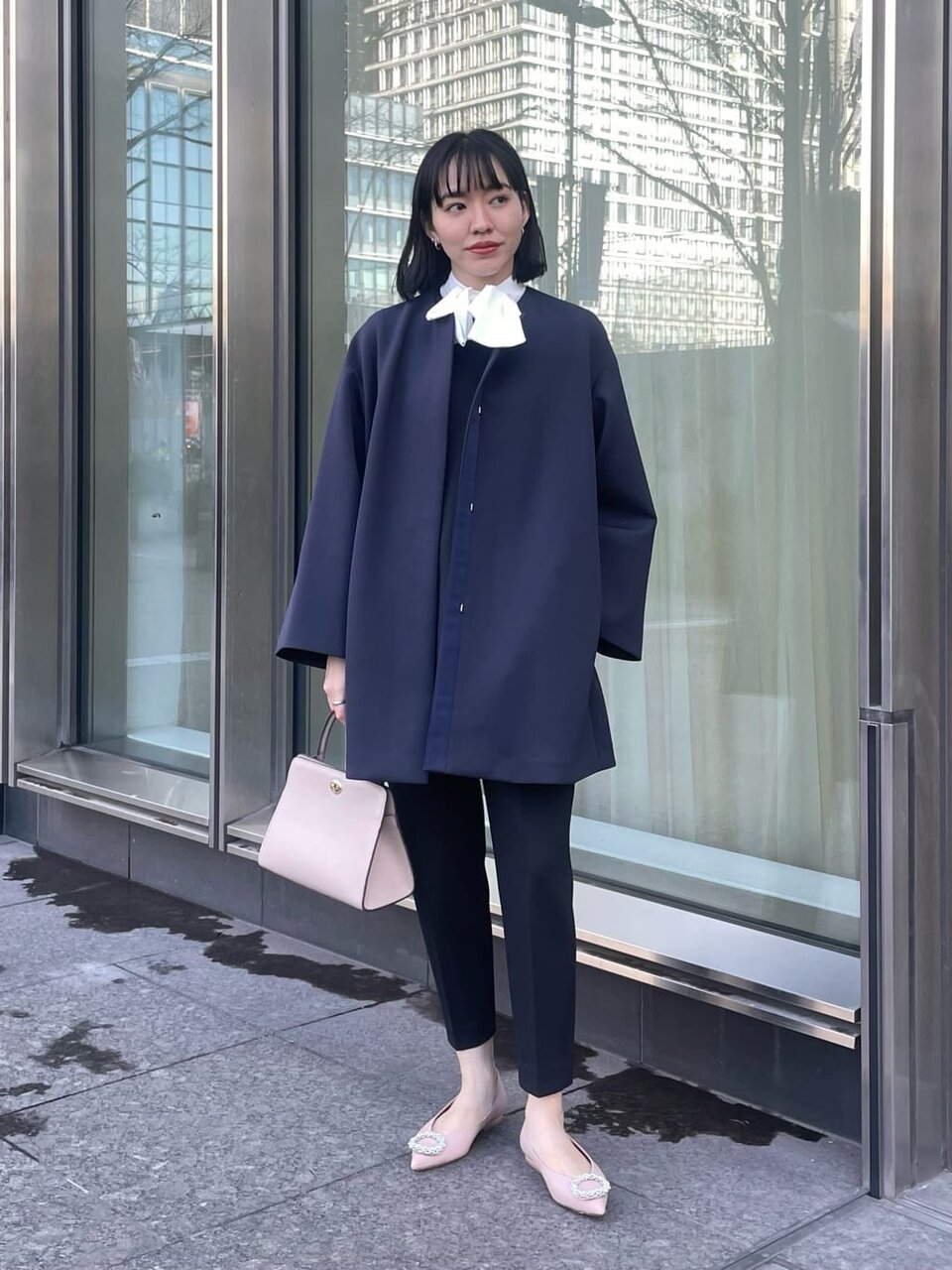 カーディガンとパールネックレスを身につけた女性