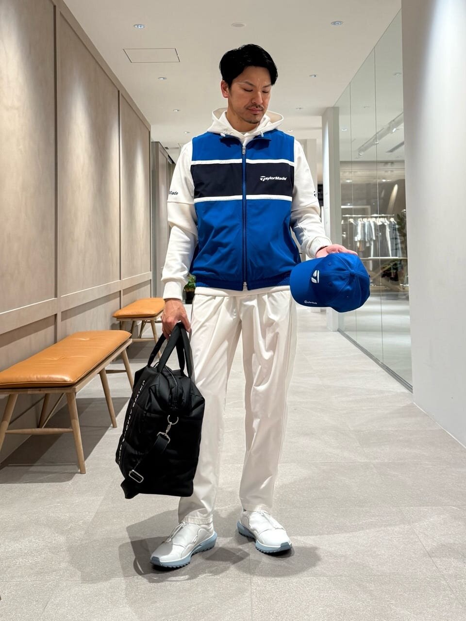 ブルーのベストと白いパンツを着た男性