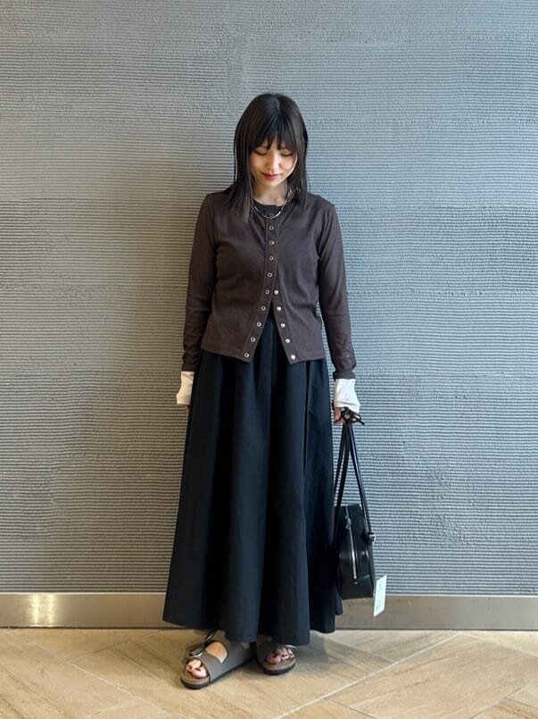 カーディガンとフレアスカートを着た女性