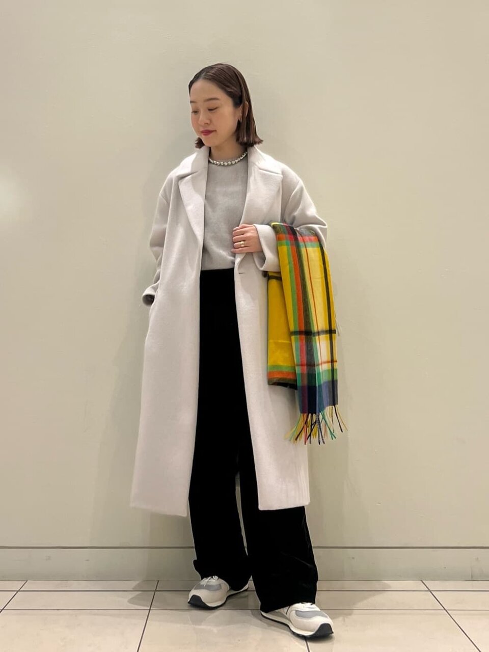 テーラードコートとベルベットパンツを着た女性