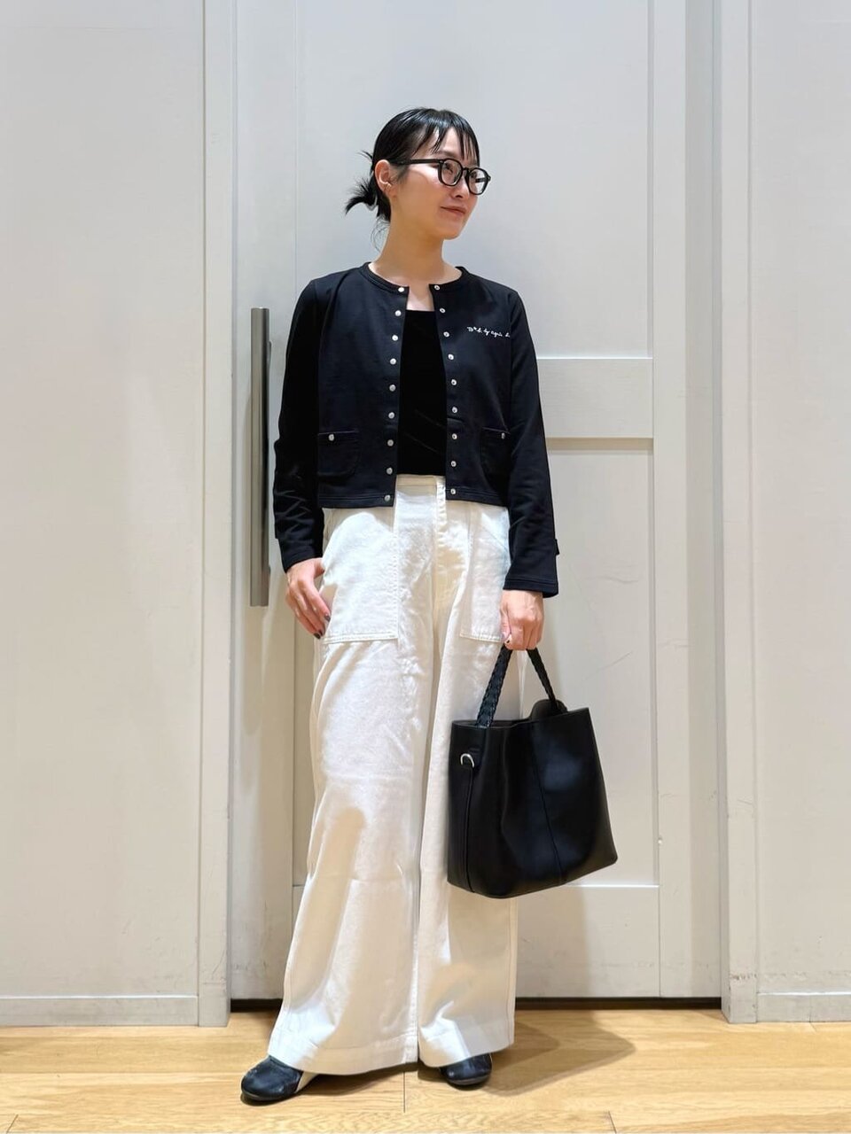 カーディガンにスリムスニーカーをあわせた女性