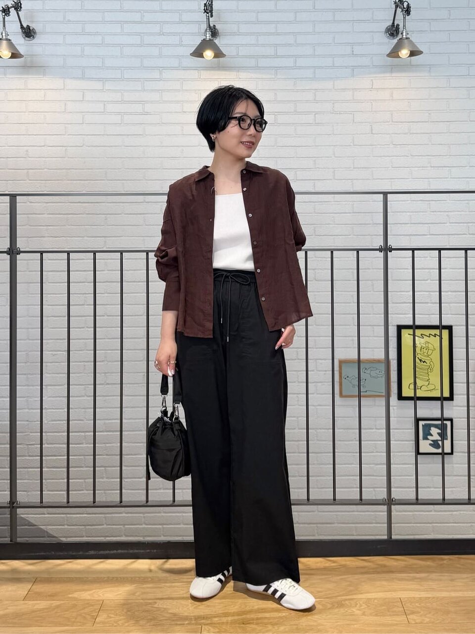リネンシャツにスリムスニーカーをあわせた女性
