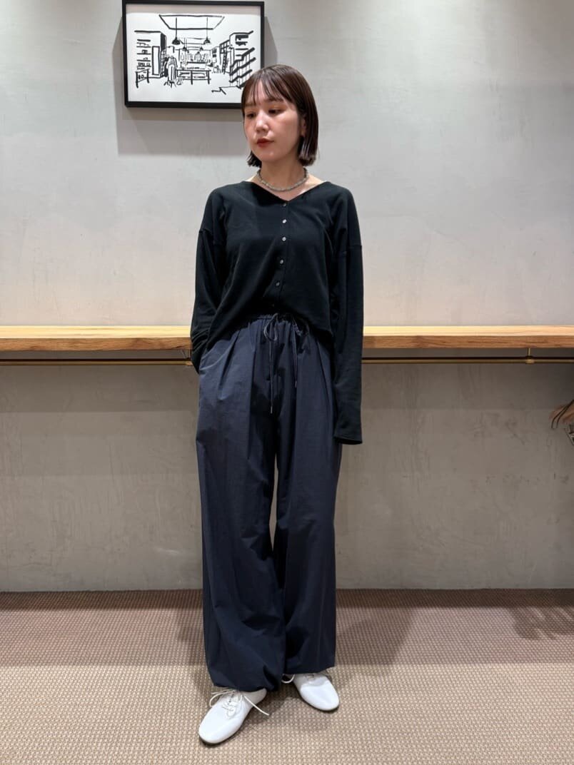 カーディガンにスリムスニーカーをあわせた女性
