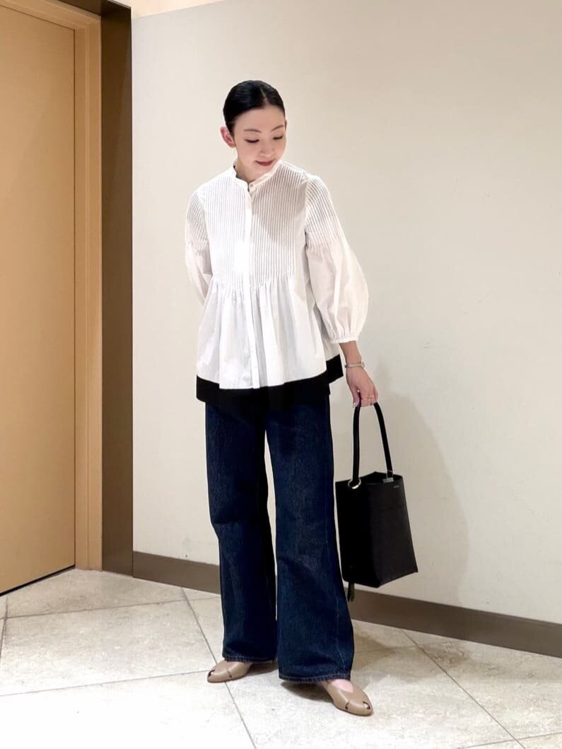 バンドカラーシャツとピープトゥパンプスをあわせた女性