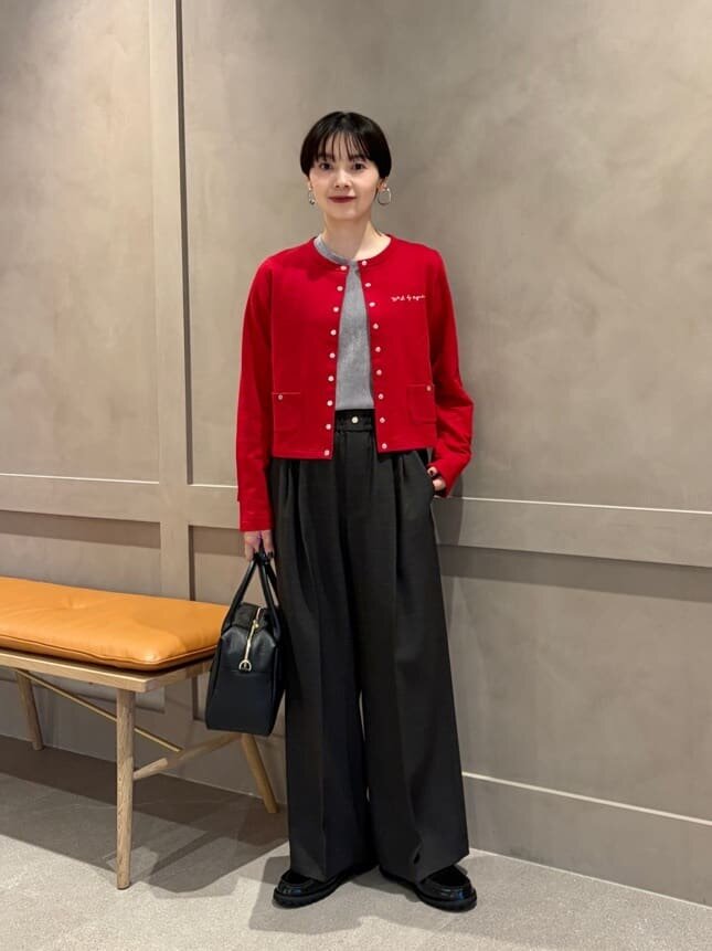 赤いカーディガンとローファーをあわせた女性