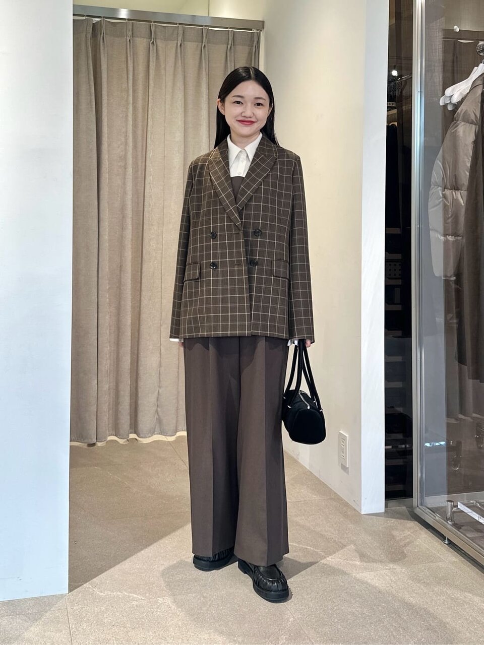 チェック柄ジャケットとローファーをあわせた女性