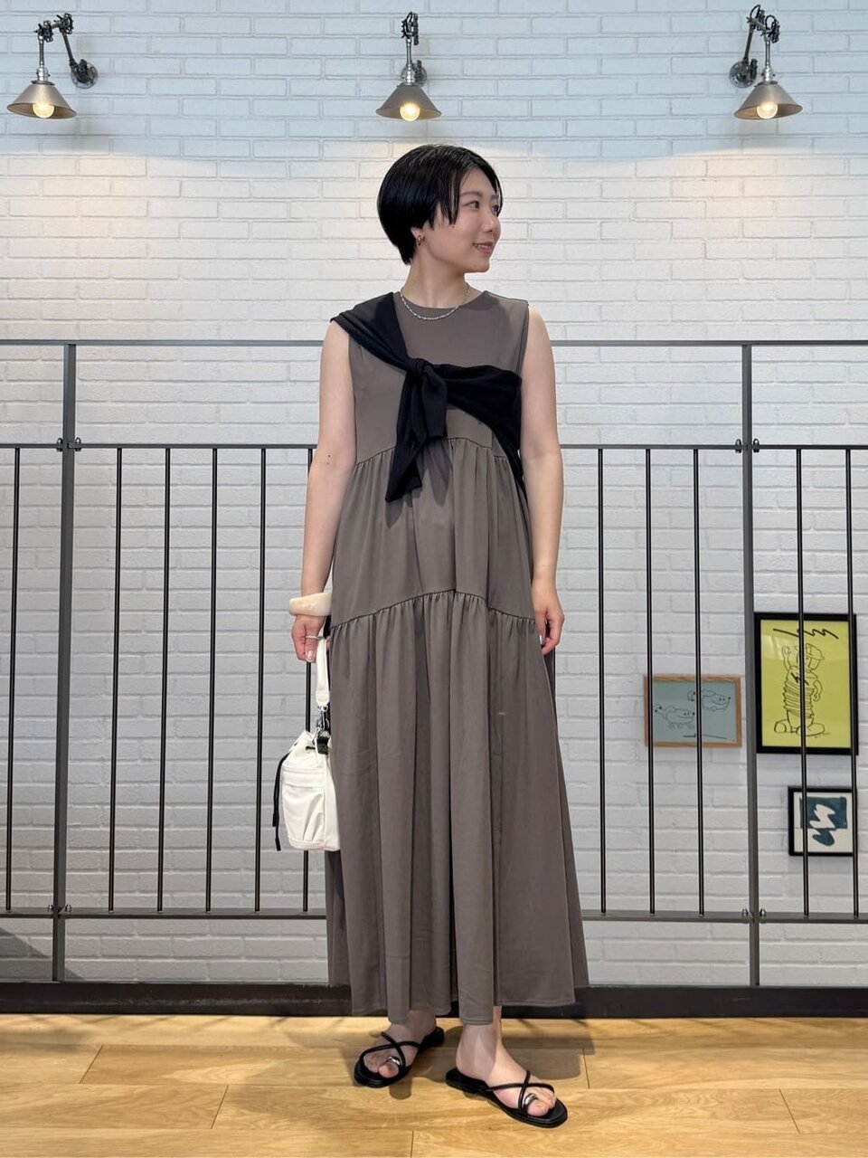 ノースリーブワンピースとカーディガンを着た女性