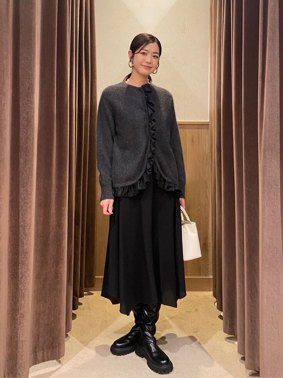 ウールカーディガンとフレアスカートを着た女性