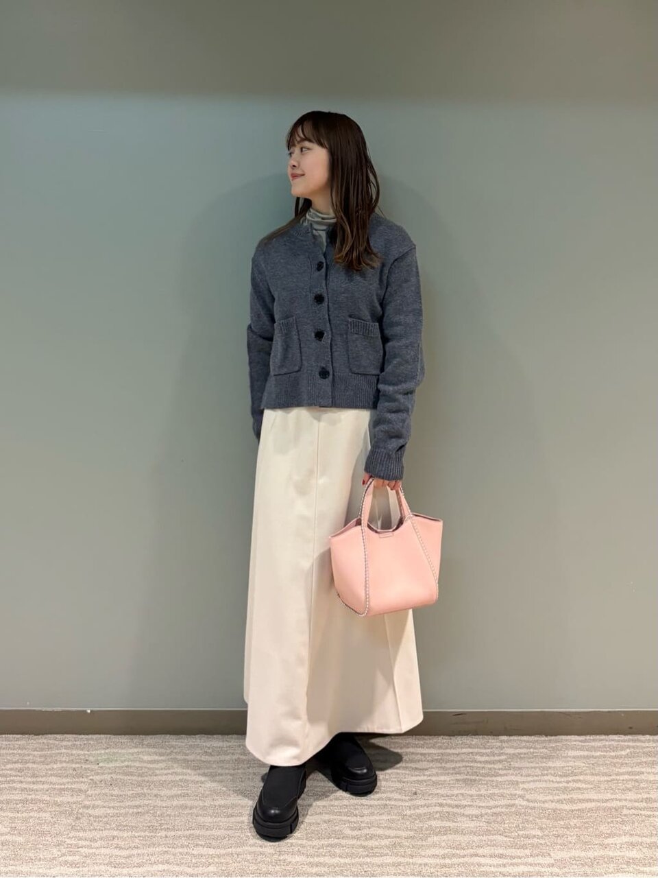 ウールカーディガンとフレアスカートを着た女性