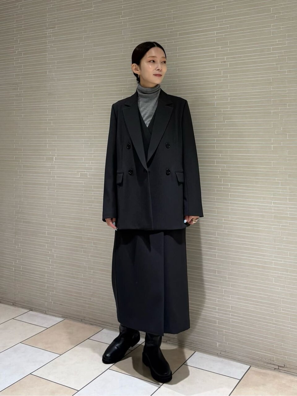 ダブルジャケットとジャンパースカートを着た女性