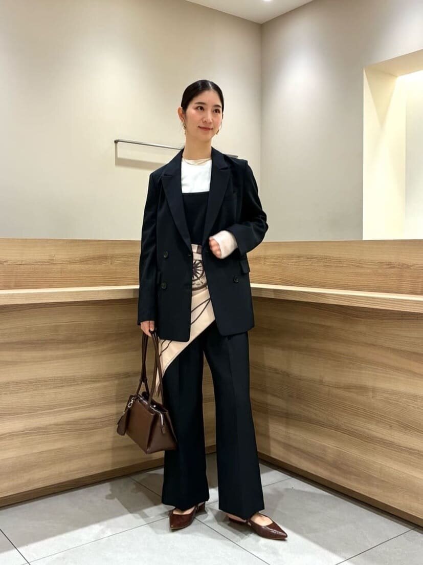 テーラードジャケットとサロペットを着た女性