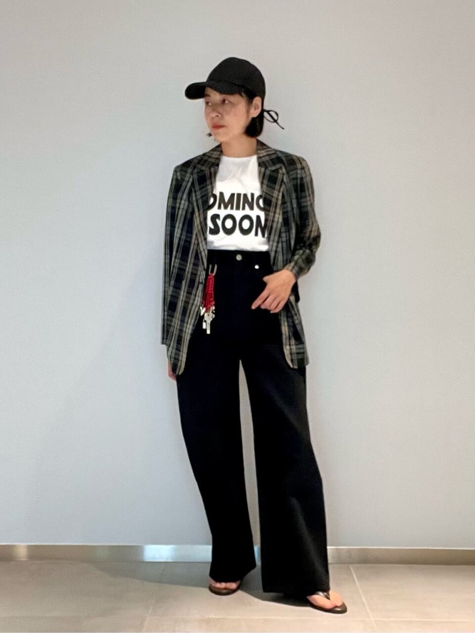 チェック柄のダブルジャケットとデニムパンツを着た女性