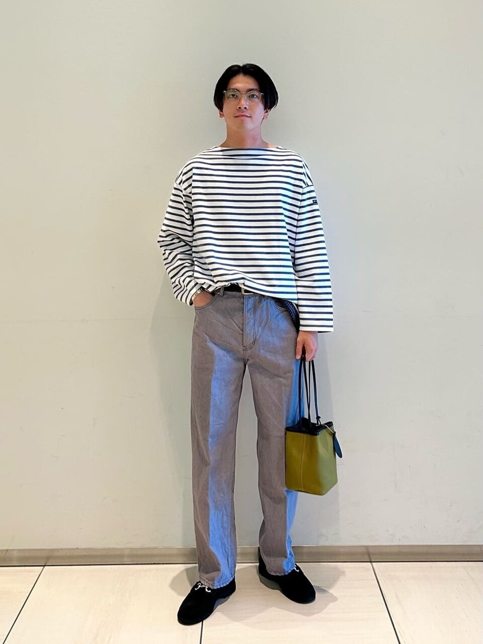 ボーダー柄カットソーとデニムパンツを着た男性