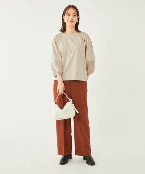 テラコッタカラーのワイドパンツを着用した女性