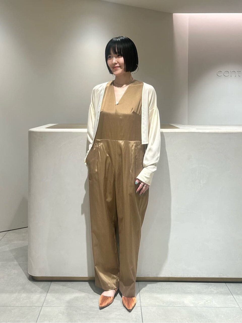 オールインワンとカーディガンを着た女性