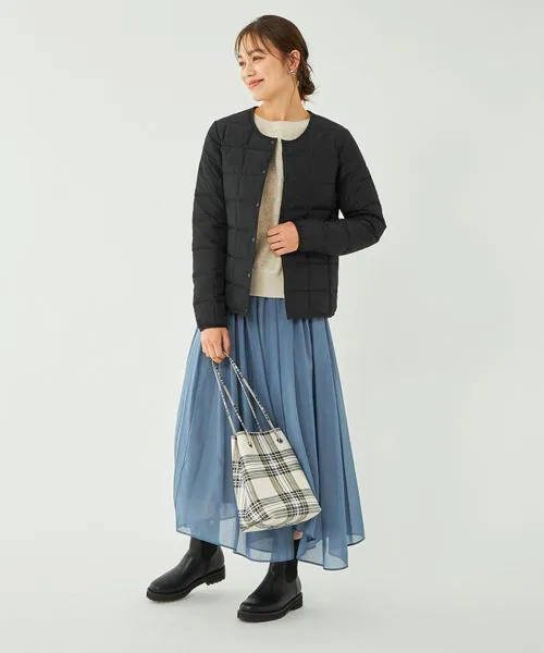 ショート丈ダウンとプリーツスカートの女性
