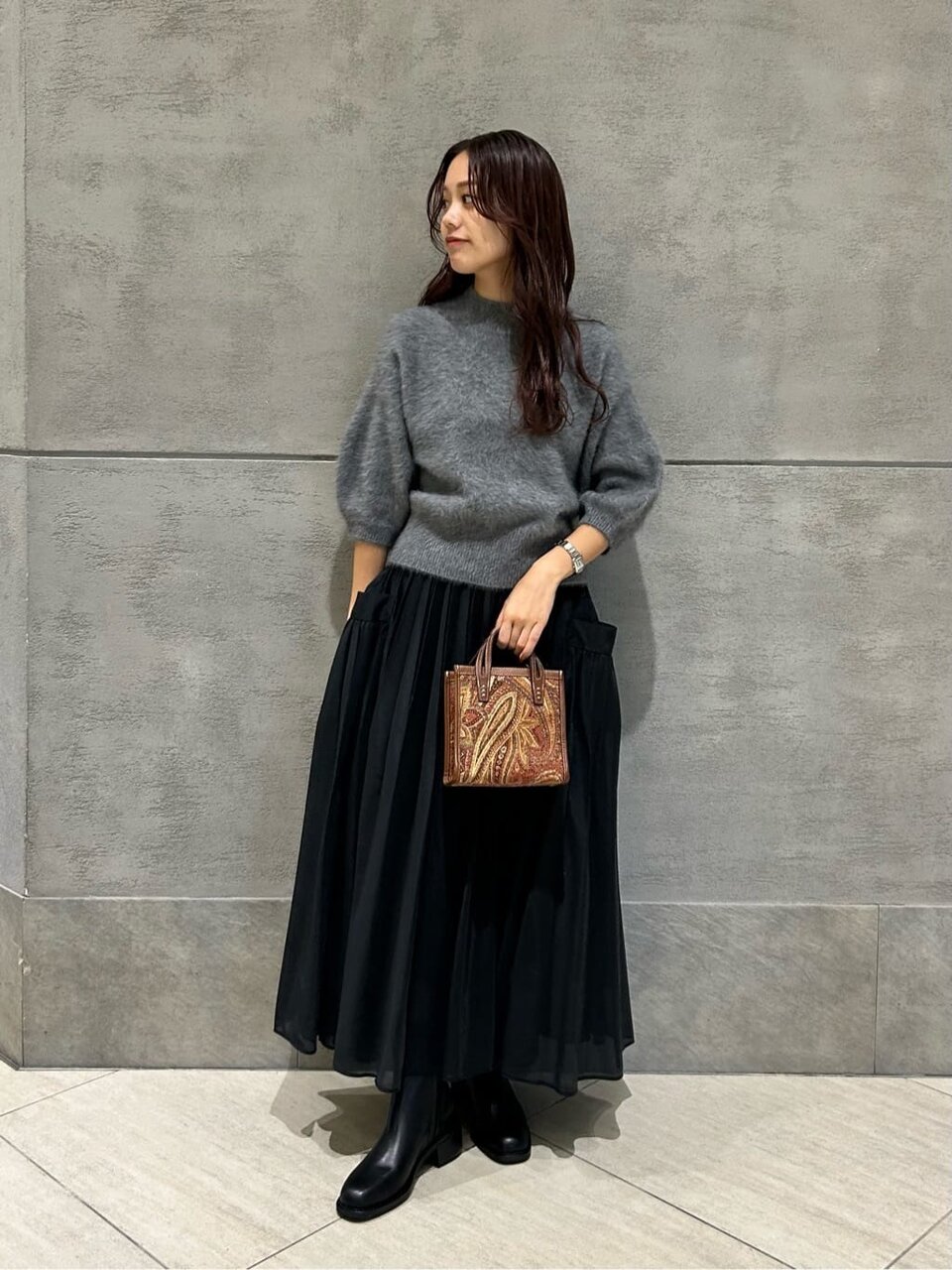ニットとフレアスカートを着た女性