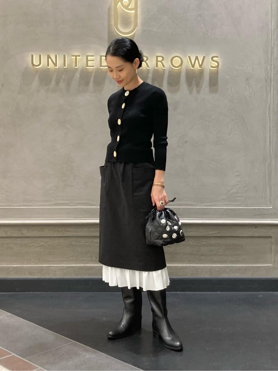 カーディガンとフリルスカートを着た女性