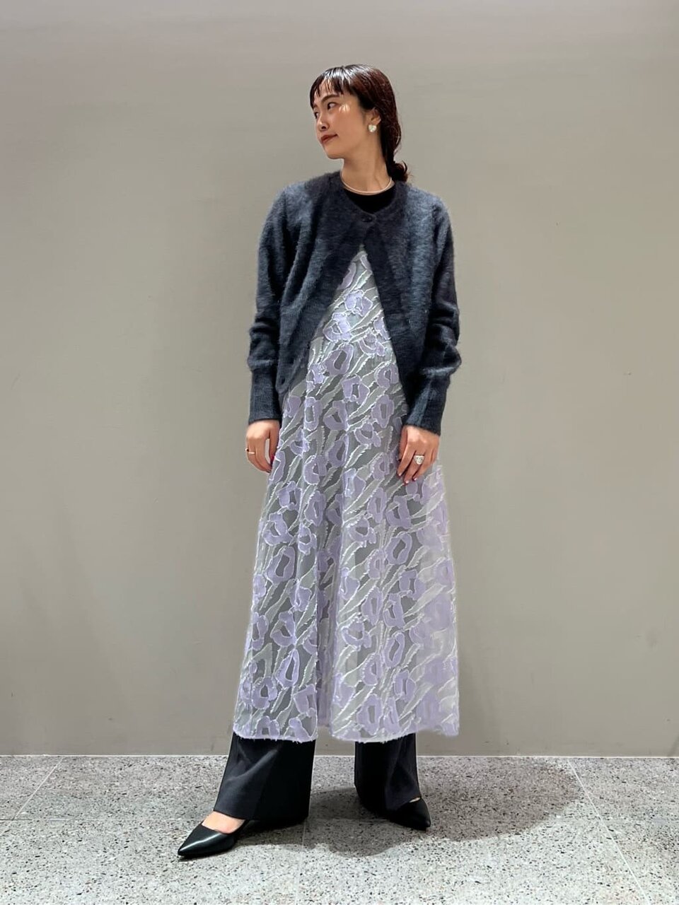 カーディガンとキャミソールワンピースを着た女性