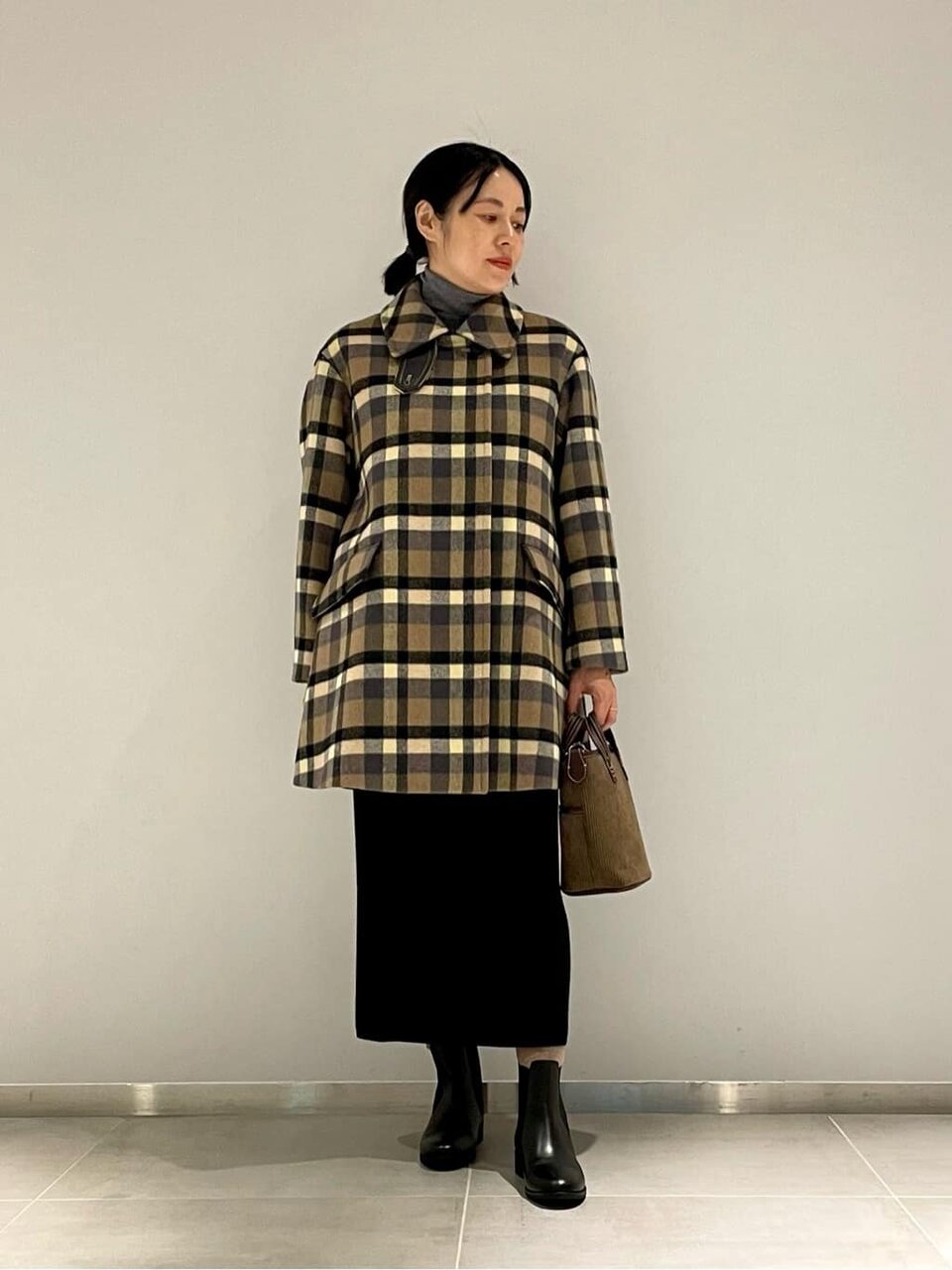 チェック柄コートとタイトスカートを着た女性